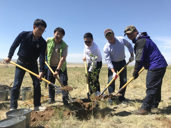 13일 오비맥주 임직원들이 푸른아시아 관계자, 몽골 에르덴 솜 주민들과 함께 '카스 희망의 숲'에서 나무를 심고 있다. (사진=오비맥주)