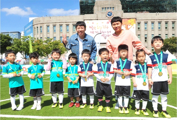 30일 서울광장에서 양세형(뒷줄 오른쪽)·세찬 형제와 마데카솔 어린이 축구교실 참가자들이 사진을 찍고 있다. (사진=동국제약) 