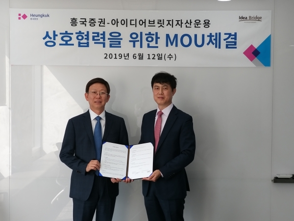 주원(왼쪽) 흥국증권 대표이사와 김문수 아이디어브릿지자산운용 대표이사(오른쪽)가 MOU 협약을 체결하고 양해각서를 들어보이고 있다.(사진=흥국증권)