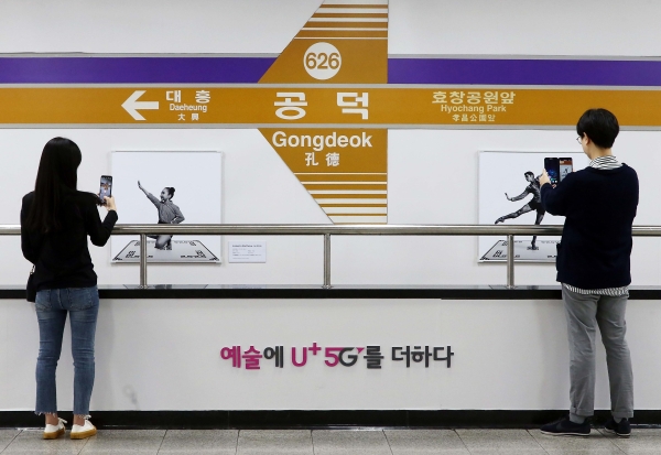 서울 지하철 6호선 공덕역에 마련된 세계 최초 5G기반 문화예술 공간 'U+5G 갤러리'에 방문한 고객이 'U+AR' 앱으로 작품을 체험하고 감상하는 모습. (사진=LG유플러스)