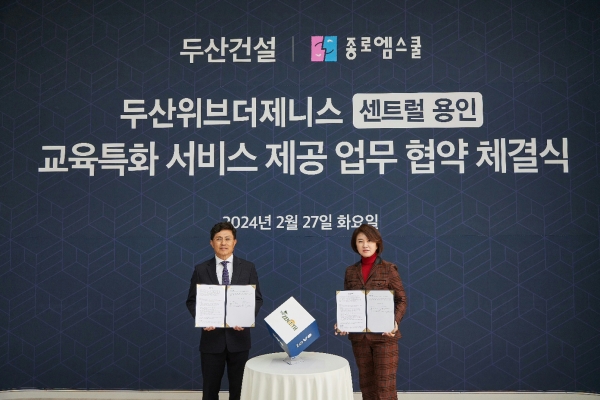 오세욱 두산건설 상무(왼쪽)와 성영남 종로엠스쿨 대표가 업무협약식에서 사진을 찍고 있다. (사진=두산건설)