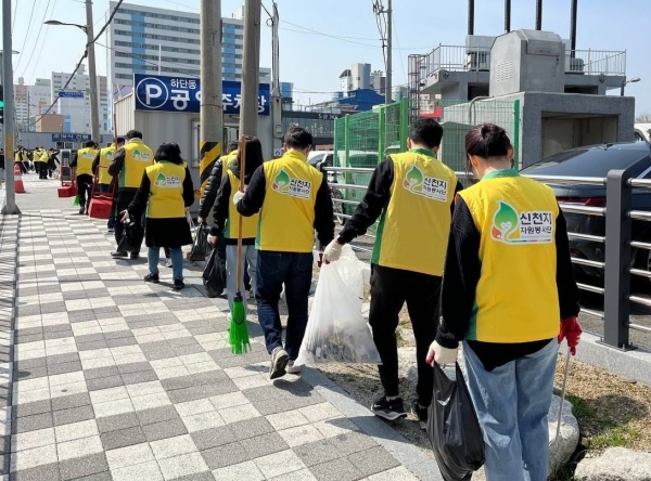 신천지 부산교회가 지난 3월 23일 사하구에 위치한 하단성전 일대에서 ‘클린하단’ 캠페인을 진행한 가운데 봉사자들이 쓰레기를 수거해 이동하고 있다. (사진=신천지 부산교회)
